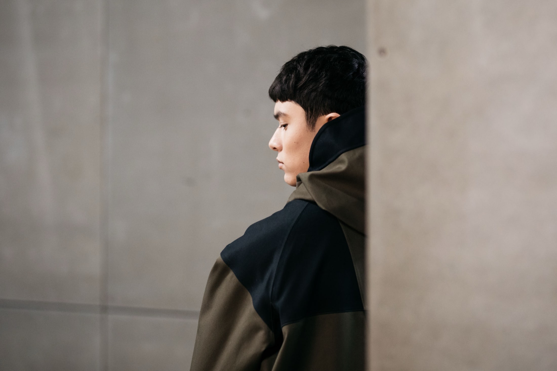 A founder in profile against a concrete wall