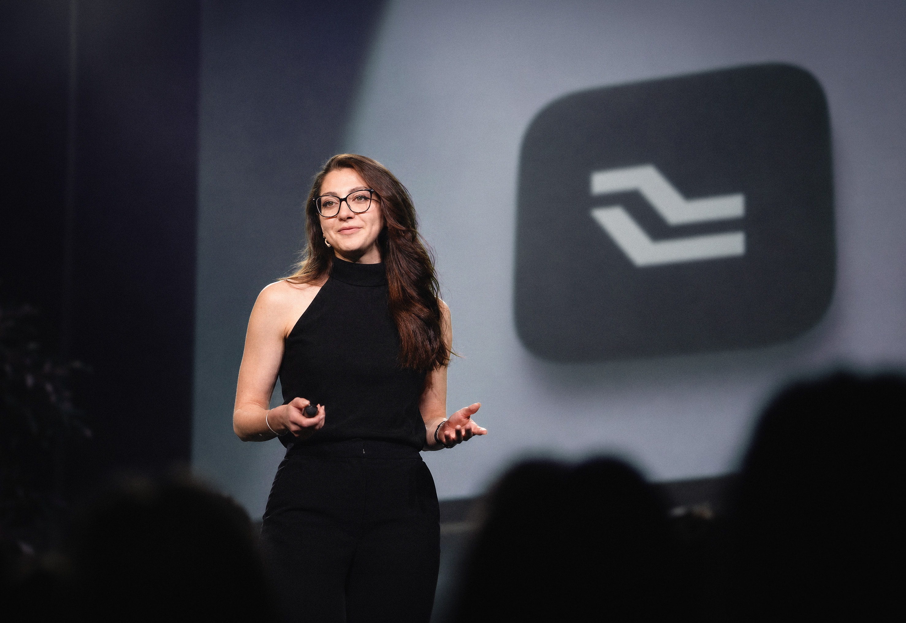A founder presenting on stage in front of a projected Longson Studio brand mark